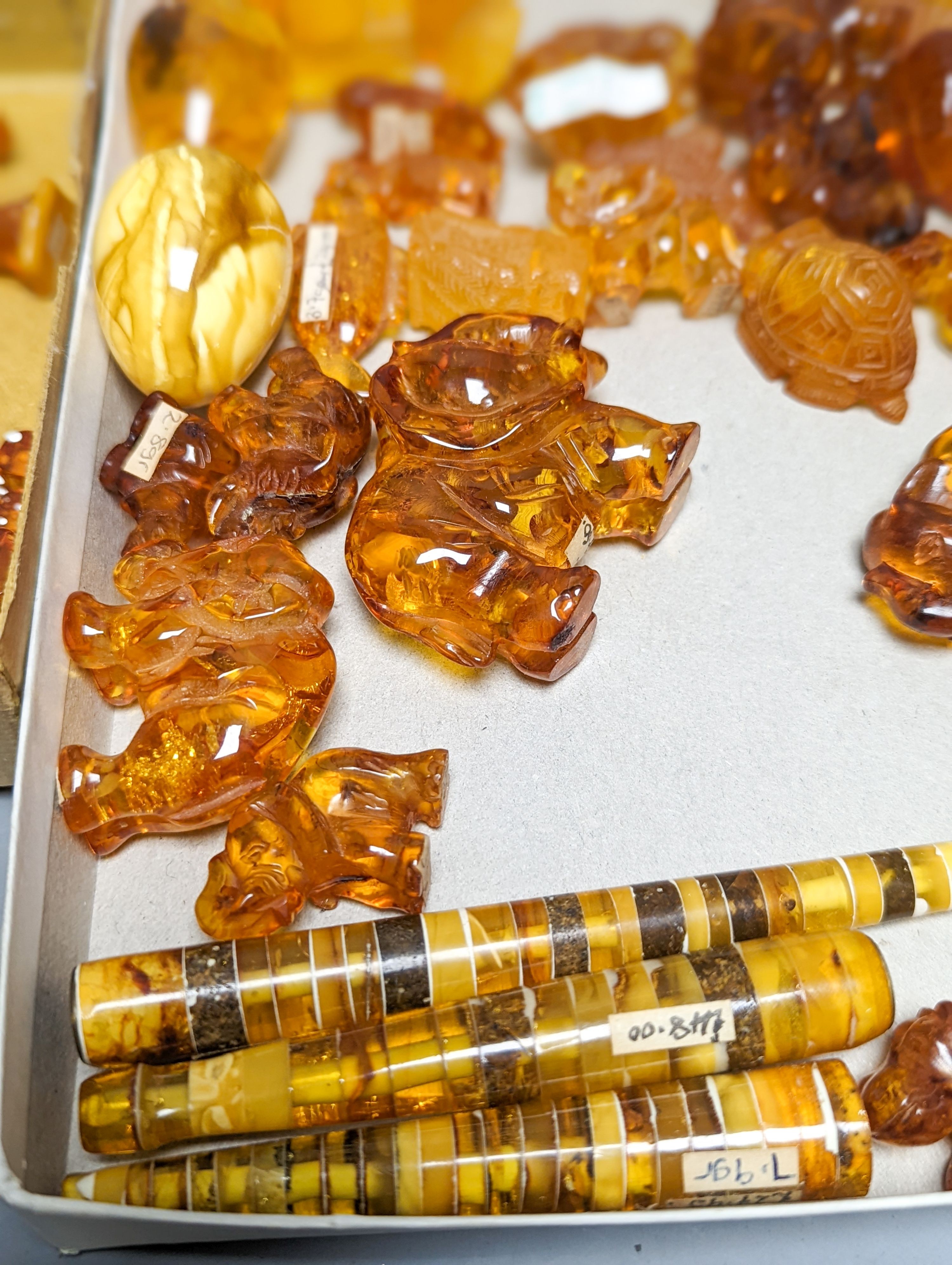 A mixed collection small carved amber wares including dice, eggs and cigarette holders, etc.